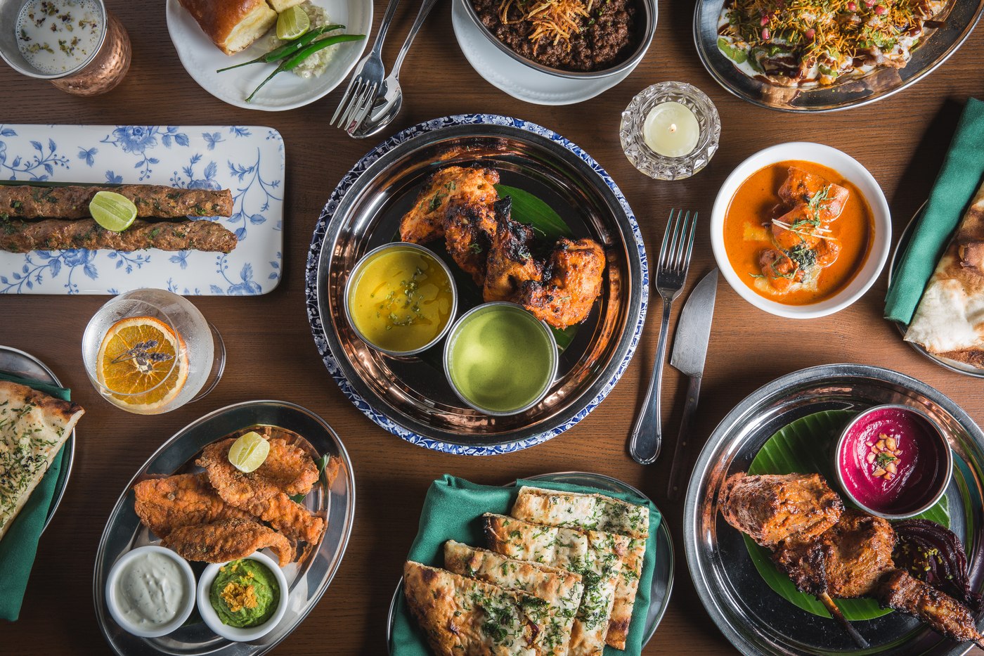An overhead spread of tandoori dishes, kebabs, curries and naan