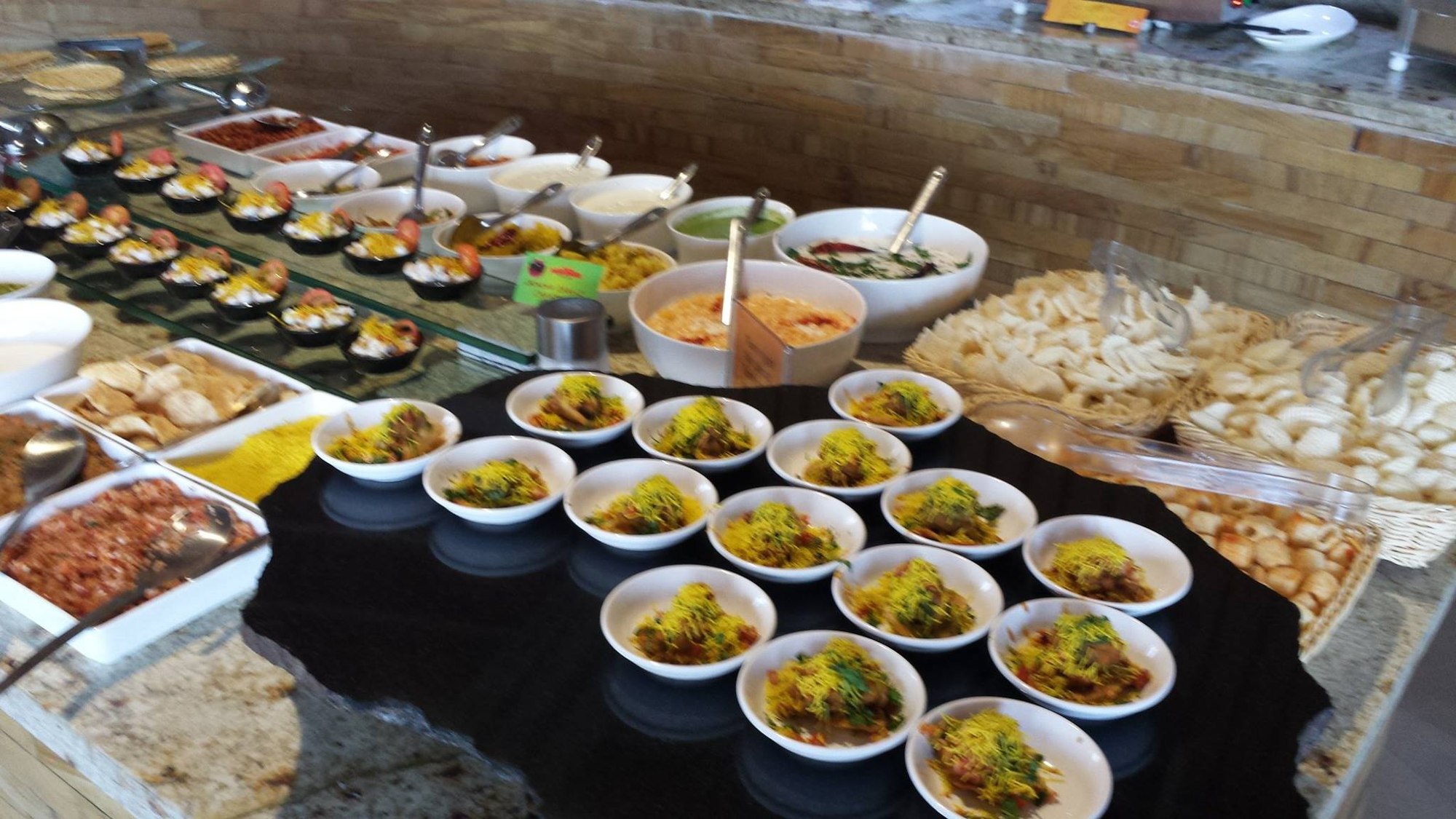 A large buffet-style catering spread of Indian dishes ready for an event