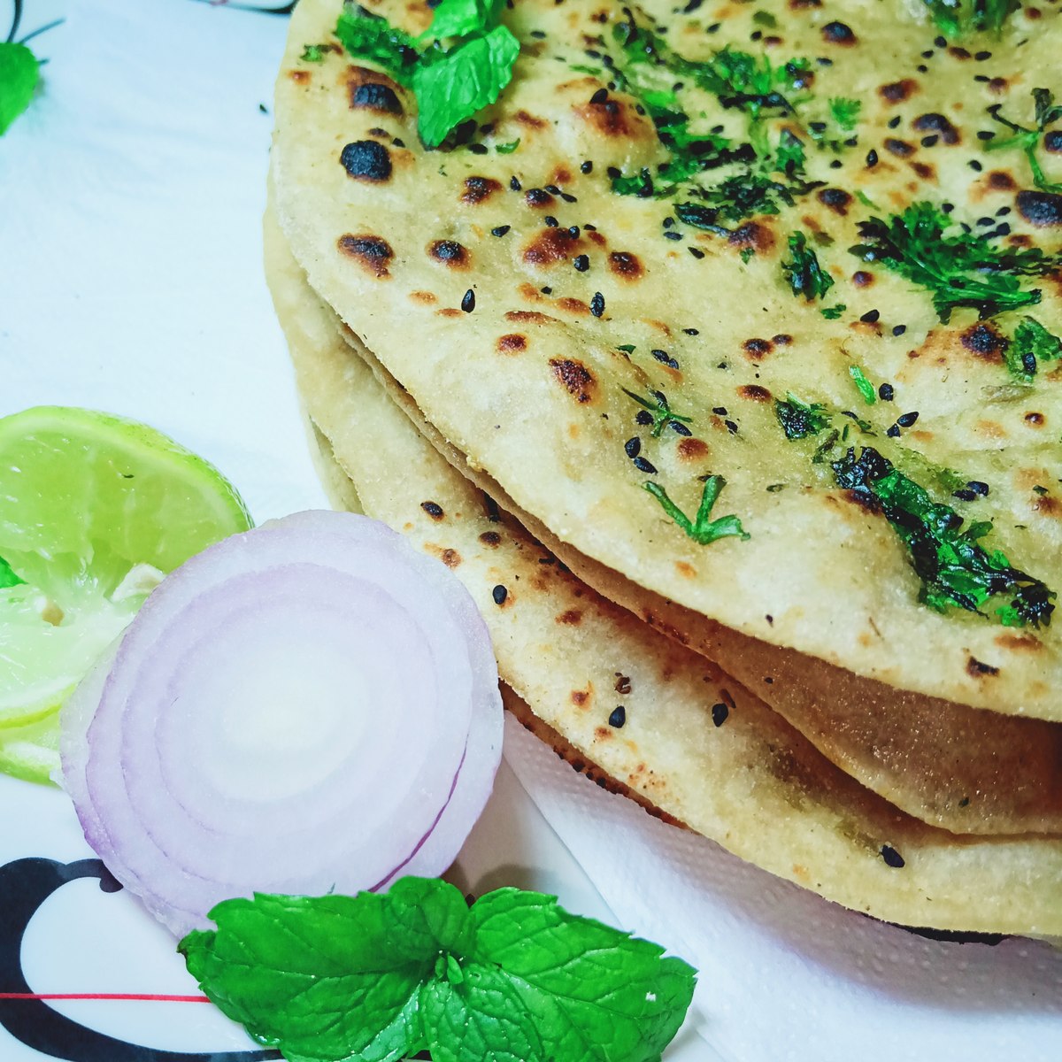 Fresh garlic naan stack with cilantro and lime