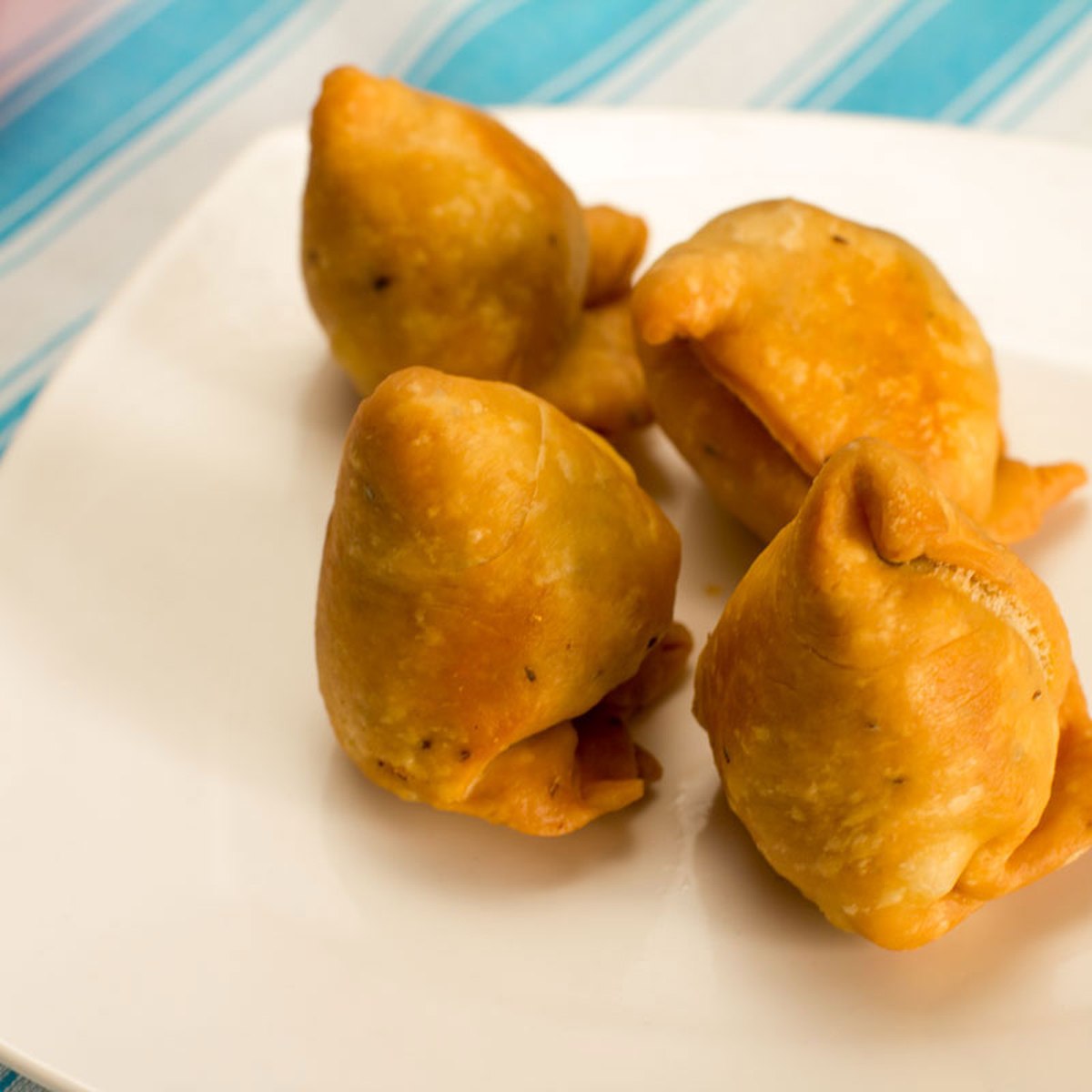 Golden fried samosas on a plate